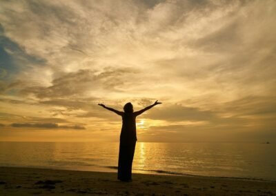 silhouette of woman standing on beach during sunset