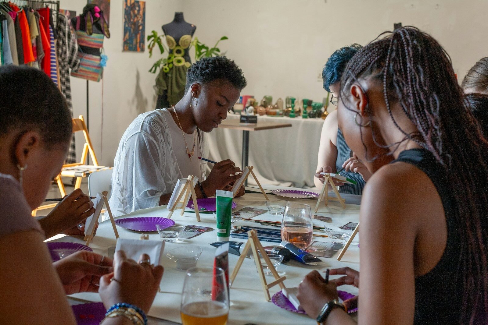 People painting at a table in an art class