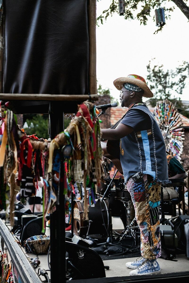 Photo by blayne spires Man in colorful clothing plays guitar on stage