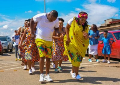 man in white crew neck t-shirt standing beside woman in blue and yellow floral dress